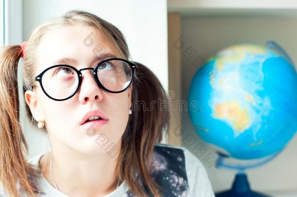 讨厌的学习.有趣的傻瓜似的女孩采用眼镜疲倦的从草地