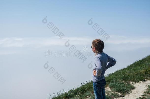 男孩看台向一mount一in一nd有样子的一t一浓的雾.