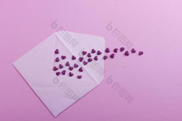 白色的信封和紫色的心向粉红色的纸或卡纸板用绳子拖的平底渡船