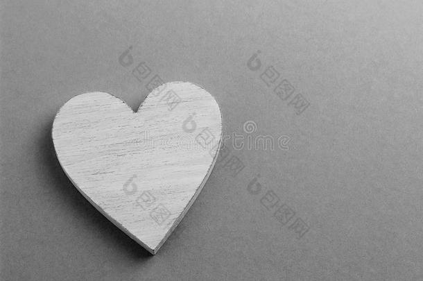 白色的木制的心向黑的和白色的卡纸板背景.