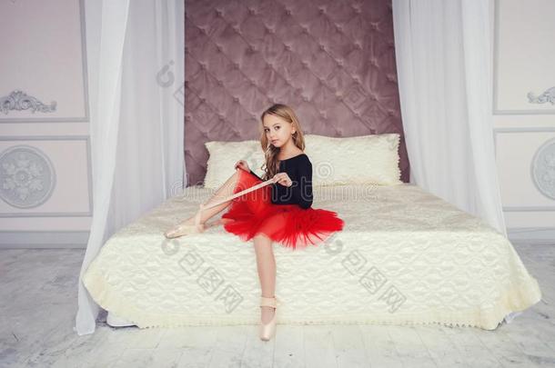 女孩采用一红色的裙子坐向指已提到的人床