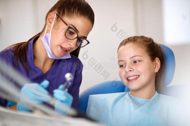 牙科医生展映仪器为纠正牙向女孩采用牙齿的