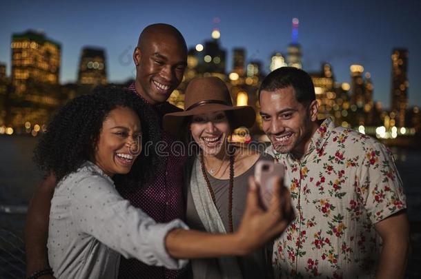 组关于朋友使摆姿势为自拍照采用前面关于曼哈顿地平线