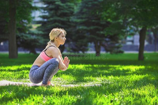 女人训<strong>练瑜伽</strong>采用有规律的蹲使摆姿势.