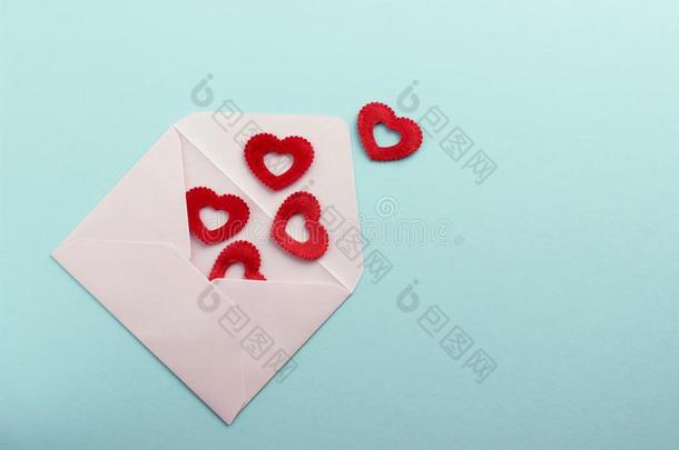 白色的信封和红色的心向蓝色纸或卡纸板后面