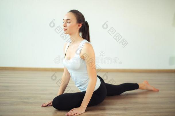 女人<strong>开业</strong>的瑜伽使摆姿势在瑜伽健康的运动<strong>健身</strong>房