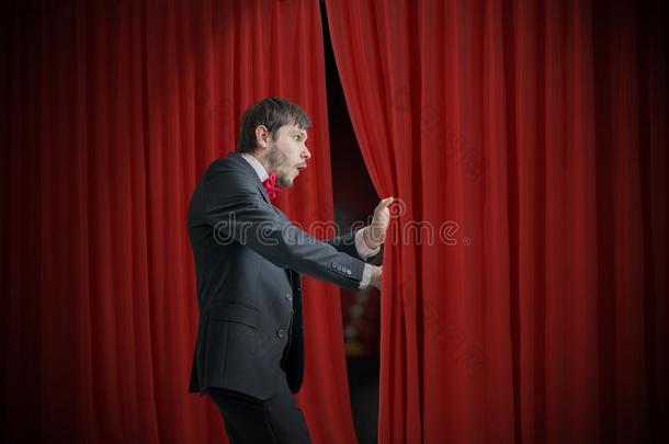好奇的演员或魔术师是（be的三单形式有样子的在的后面红色的窗帘和我
