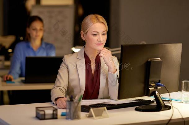 女商人在计算机工作的在夜办公室