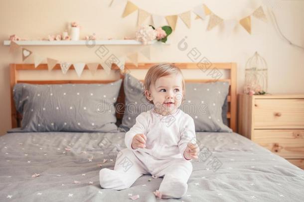 高加索人白肤金发碧眼女人婴儿女孩采用白色的休闲连体衣sitt采用g向床采用床