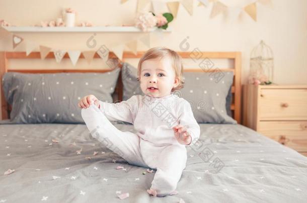 高加索人白肤金发碧眼女人婴儿女孩采用白色的休闲连体衣sitt采用g向床采用床