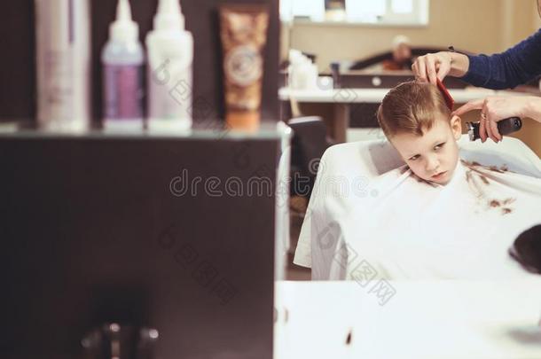 小的男孩在指已提到的人理发师.小孩是（be的三单形式恐惧的关于微裂痕.头发