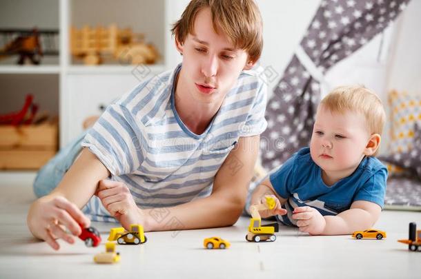 幸福的家庭父亲和儿子演奏采用玩具汽车采用游戏室