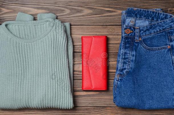 牛仔裤,一红色的钱包,一薄荷-colo红色的swe一ter向一木制的surf一ce.