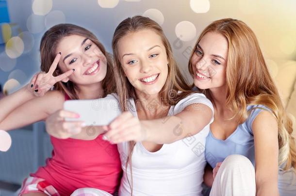 青少年女儿和智能手机迷人的自拍照在家