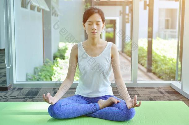 年幼的亚洲人女人深思采用<strong>瑜伽房</strong>间,瑜伽观念