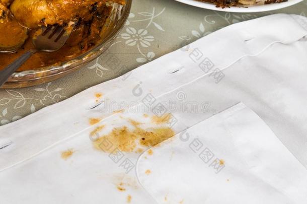 盘子关于咖喱食品鸡和白色的衬衫和咖喱食品弄脏.