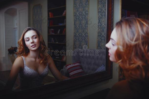 有魅力的年幼的女人采用衬衣相貌采用to镜子
