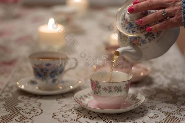 传布茶水进入中酿酒的杯子向蕾丝桌布