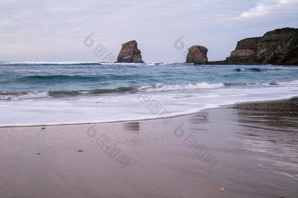 沙的海滩采用软的富有色彩的日落和悬崖和岩石飘零双燕jointuse联合使用