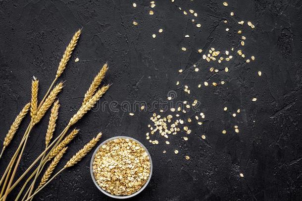 谷类植物背景.生的燕麦片在近处带叶小枝关于小麦向黑的波黑