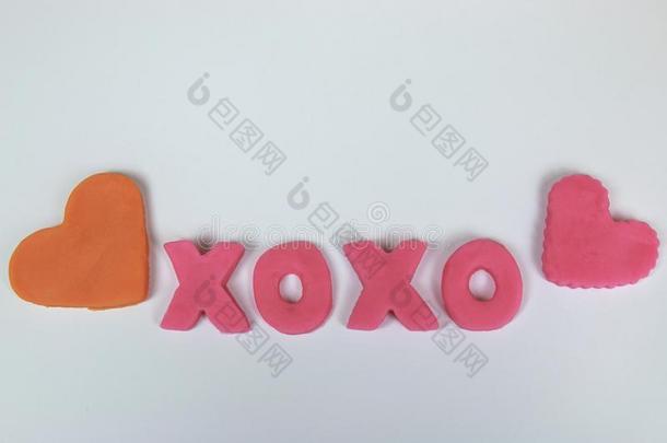 粉红色的塑像用黏土和黏土文学拼写亲亲抱抱。用于书信或<strong>短</strong>信<strong>结尾</strong>表示爱的温暖问候。“X”的含义：Kiss紧抱和吻wickets三柱门
