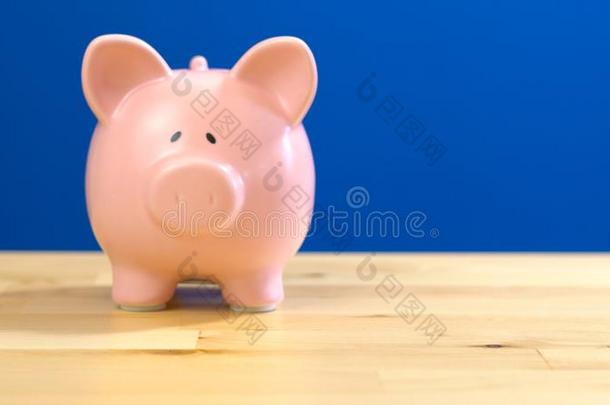 小猪银行反对蓝色背景和复制品空间.