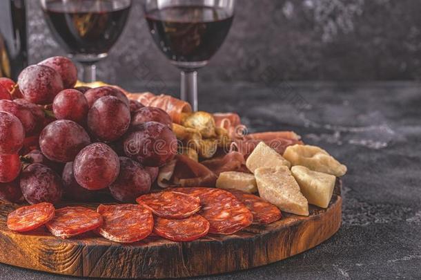 意大利熏火腿,香肠,葡萄酒,葡萄,帕尔马干酪向黑暗的表.