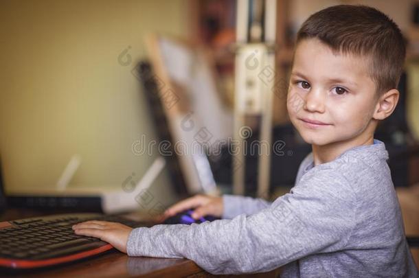 年幼的男孩演奏运动向一桌面计算机