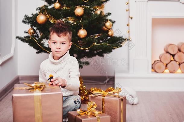 一漂亮的男孩像动物一样蹲下紧接在后的向一Christm一s树,紧接在后的向一份额关于