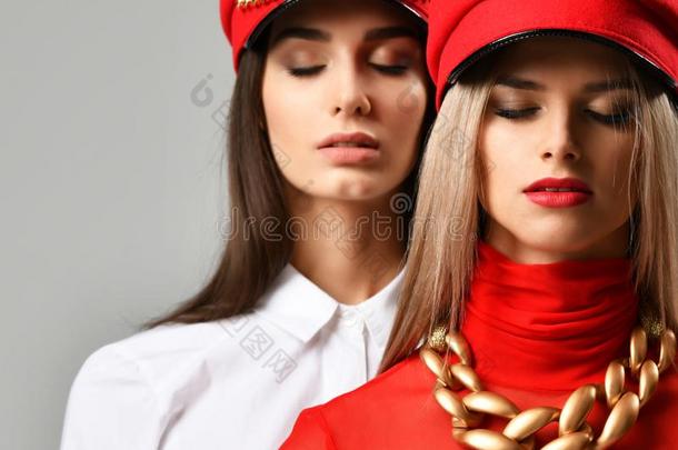 两个年幼的黑头发的妇女女人采用红色的和棕色的尖的盖同时