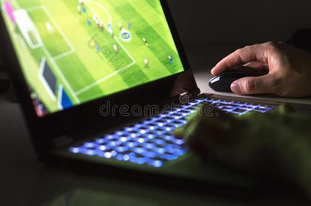 年幼的男人演奏足球或足球游戏在线的和便携式电脑