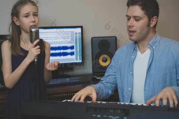 男人和小的女孩采用音乐工作室.
