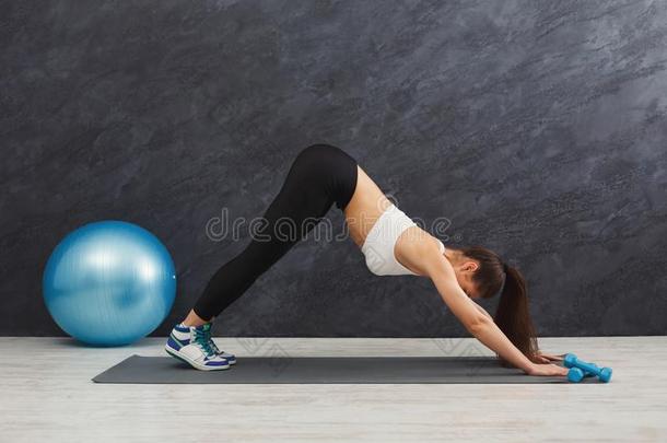 女人训<strong>练瑜伽</strong>采用狗使摆姿势采用健身房