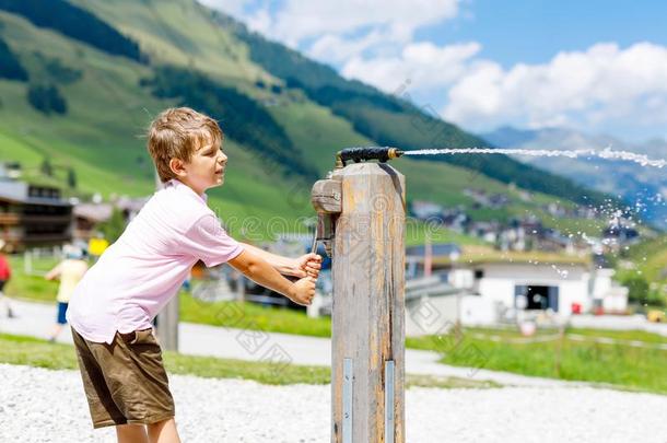 小的学校小孩男孩演奏和水泵向热的夏一天