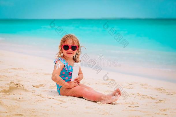 太阳保护向海滩-小的女孩应用防晒霜乳霜向