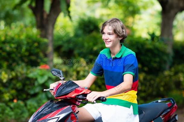 十几岁的青少年骑马小型摩托车.男孩向摩托车.