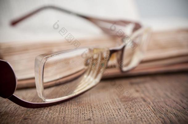 眼镜向古代的书敞开的向木制的表后台