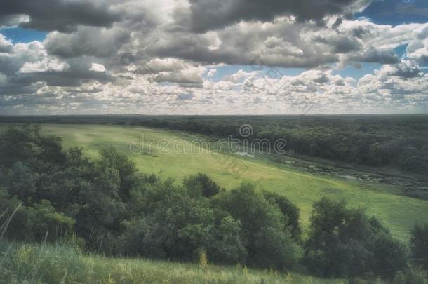 风景优美的俄国的风景.草地,河和小山在下面一云