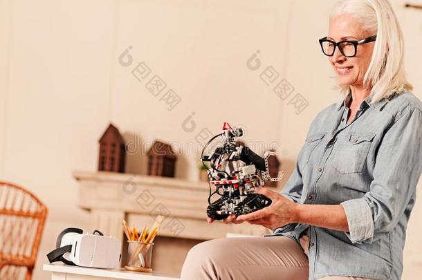 好奇的上了年纪的女人仔细检查机器人的机器