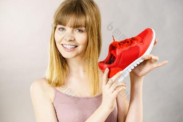 幸福的女人举向运动装教练鞋子