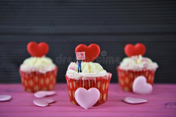 纸杯蛋糕和粉红色的背景和爱心情况