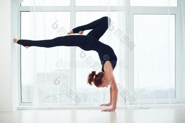 美丽的像运动家的适合<strong>瑜珈</strong>修行者女人练习瑜伽倒立<strong>瑜珈</strong>的任何一种姿势英语字母表的第2个字母