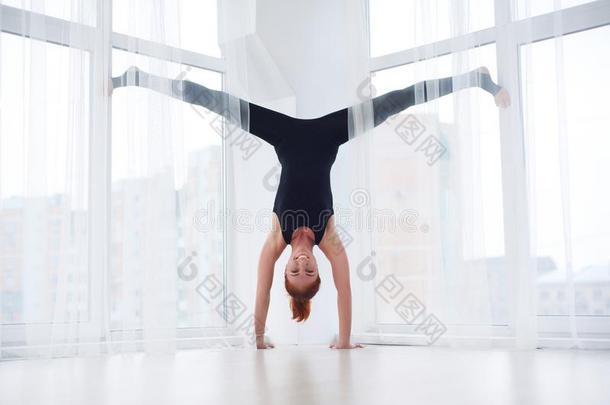 美丽的像运动家的适合瑜珈修行者女人练习瑜伽倒立瑜珈的任何一种姿势一