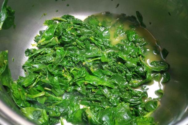 多汁的煮熟的绿色的菠菜采用一银碗