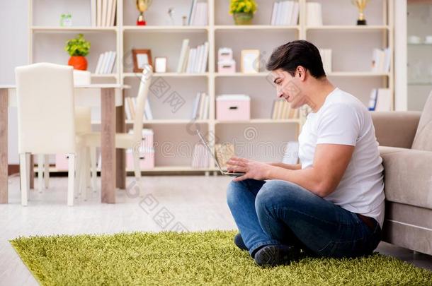 指已提到的人男人工作的向便携式电脑在家向地毯地面