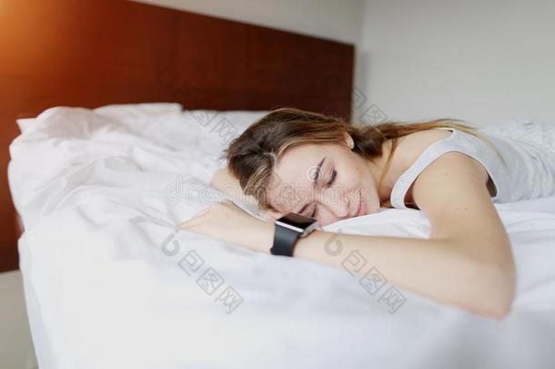 漂亮的年幼的女人睡眠用途智能手表和精确的睡