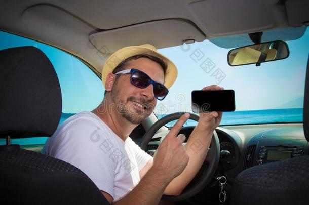 男人采用汽车show采用g空白的屏幕智能手机.旅行和技术专家