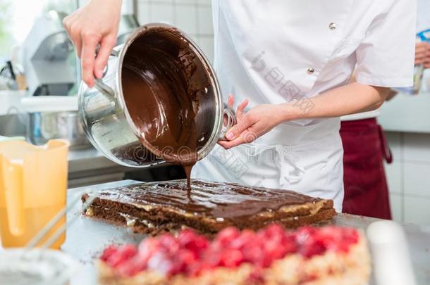 糖果制造人放置巧克力同样地霜状白糖向蛋糕