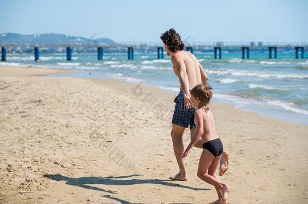 爸爸和他的儿子跑<strong>一起</strong>指已提到的人海滩向指已提到的人码头采用swimm采用gt跑