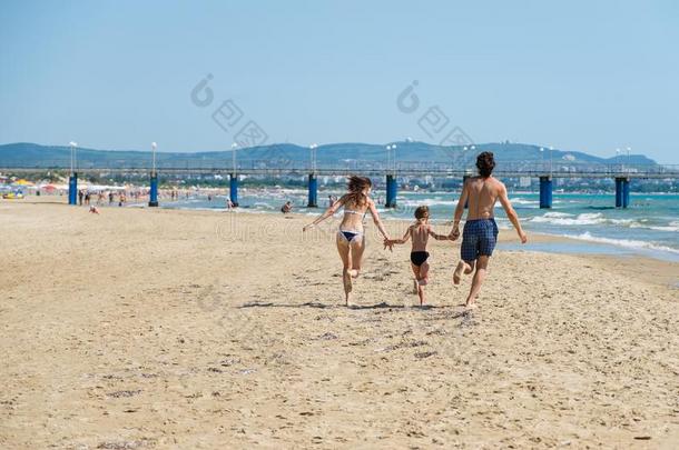 妈妈,爸爸和儿子跑一起指已提到的人海滩佃户租种的土地h和s.海滩假日